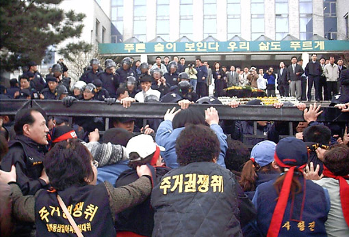 시위대들이 구청 진입을 시도하며 철제문을 안으로 밀어붙이고 있다.. 결국 철제문은 부숴지며 넘어졌다 